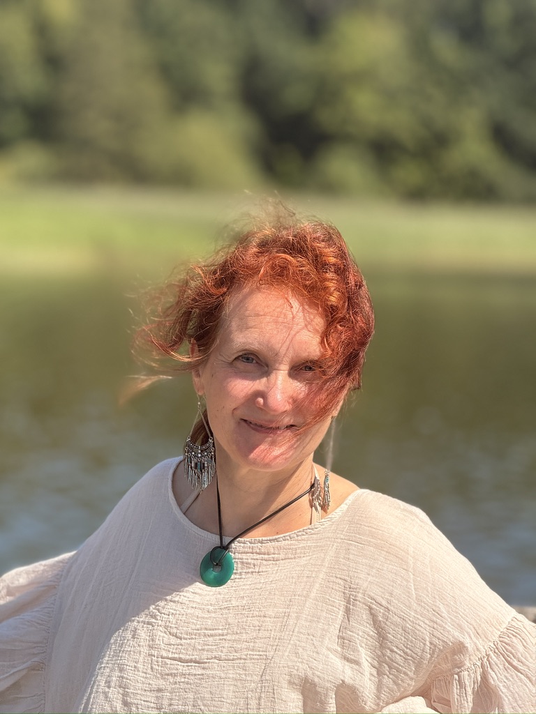 Ruth Gröger, lächelnd im Freien am Wasser